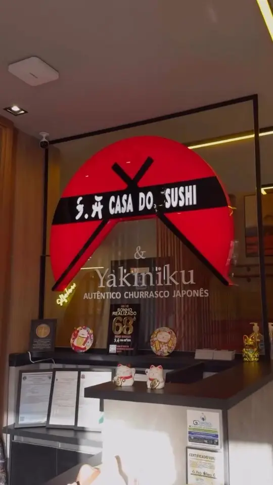 Entrada do S.A Yakiniku, com o letreiro vermelho iluminado sobre o balcão.